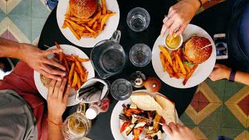 Imagem ilustrativa de pessoas comendo fast food - Pixabay